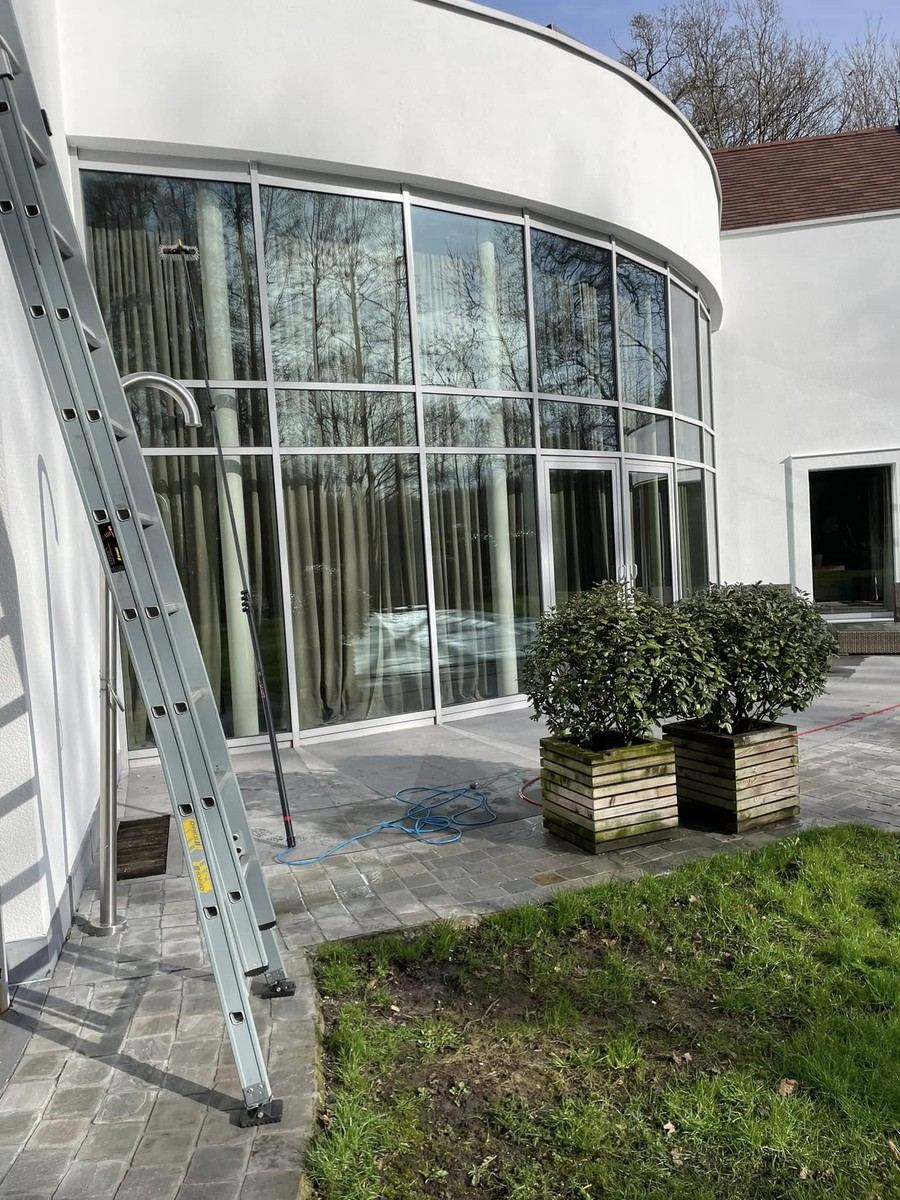 Ladder tegen een glazen gevel met een ronde vorm