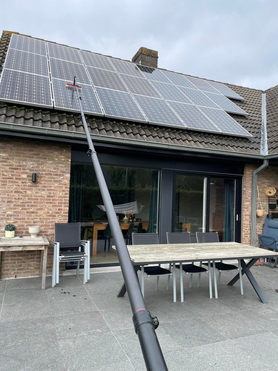 Zonnepanelen op een dak, gereinigd met een lange waterborstel